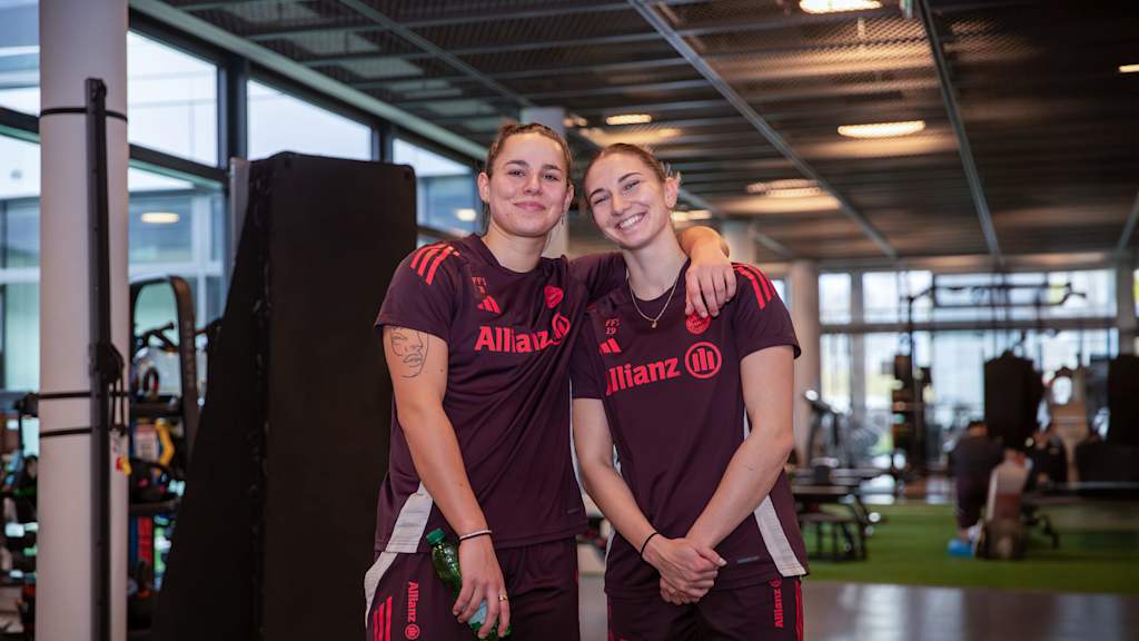 Porträt von Lena Oberdorf und Kathi Naschenweng Arm in Arm mit FC Bayern-Trainingsklamotten während der Reha am FC Bayern Campus.