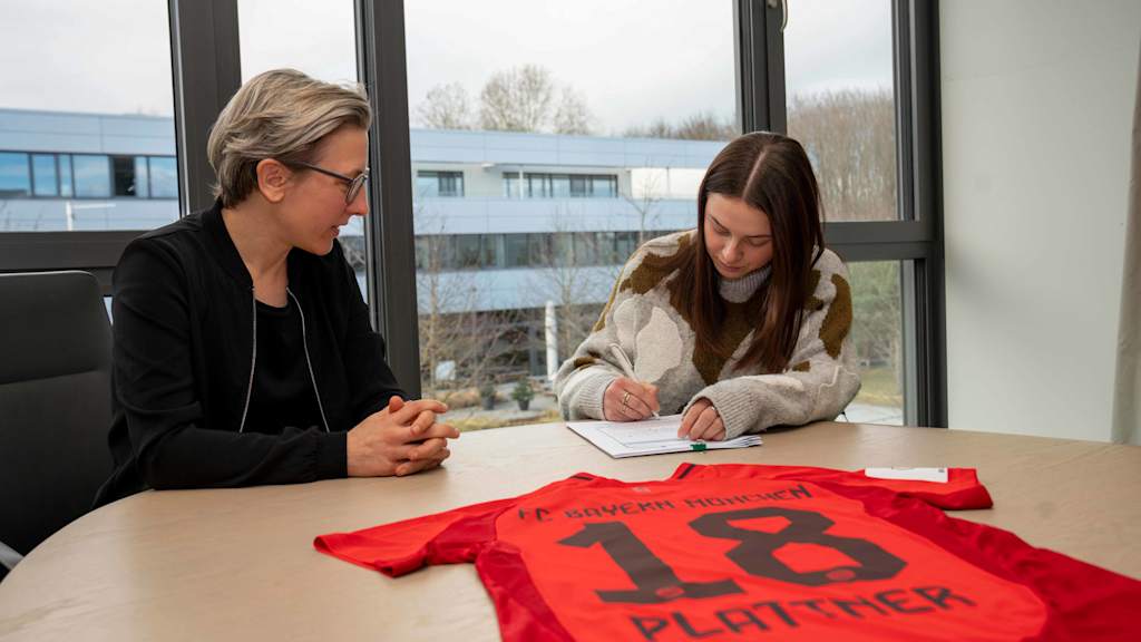 Maria Plattner bei der Vertragsunterschrift beim FC Bayern mit einem Stift in der Hand.