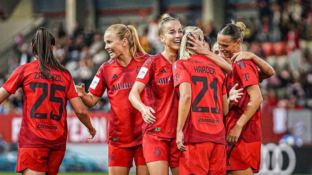 Eine Gruppe von Spielerinnen liegt sich jubelnd in den Armen.