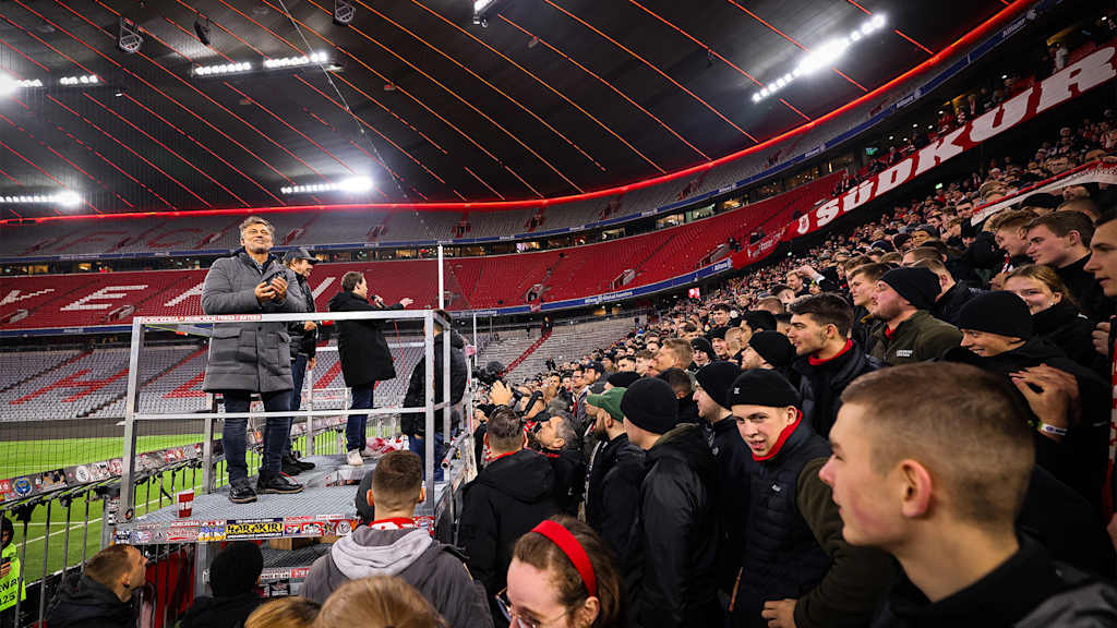 Startenor Jonas Kaufmann blickt von einem Podest auf die Fans in der Südkurve in der Münchner Allianz Arena.