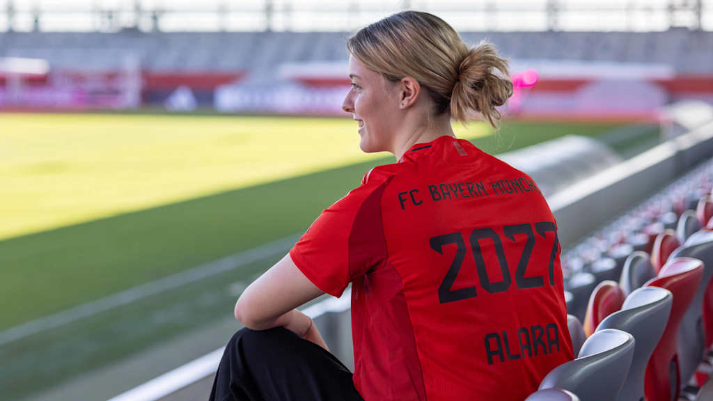 Alara Şehitler posiert auf der Tribüne des FC Bayern Campus mit dem Trikot mit der Rückennummer 2027.