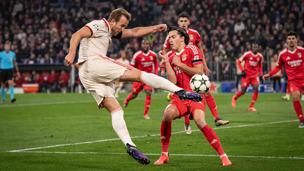 Harry Kane takes the ball first-time in the air, a Benfica defender tries to block