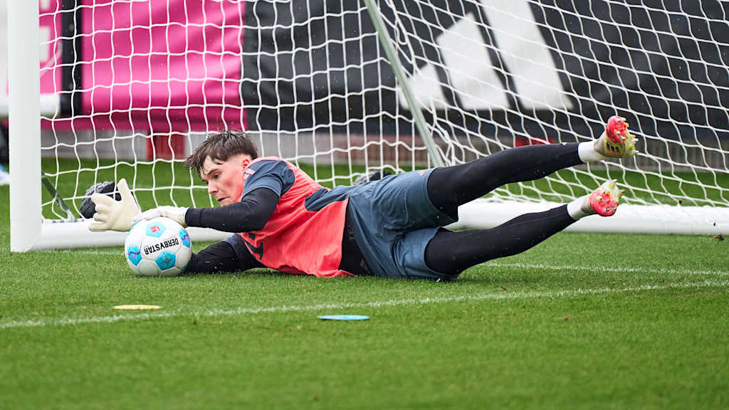 Leon Klanac hält im Training des FC Bayern einen Ball.