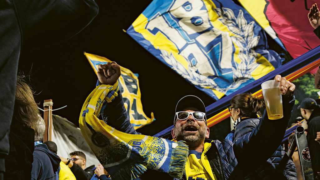 Fan with a beer in his hand in the stands of Union Saint-Gilloise