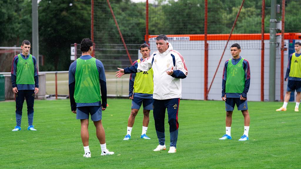 Roy Makaay erklärt auf dem Trainingsplatz ein paar Spielern in Leibchen etwas.