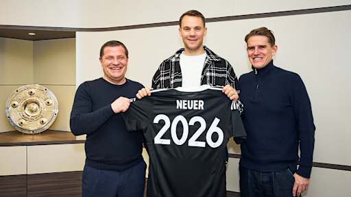 Max Eberl, Manuel Neuer und Christoph Freund stehen nebeneinander und halten ein Trikot mit Neuer 2026 hoch