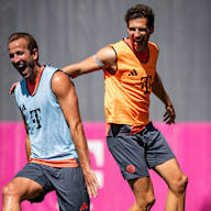 Harry Kane und Leon Goretzka lachend beim Warmlaufen im Training des FC Bayern vor dem Pokalspiel in Wiesbaden.
