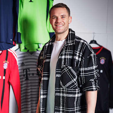 Manuel Neuer steht vor seinen Trikots