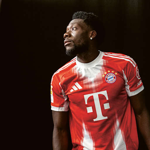 Alphonso Davies im roten Bayern-Trikot vor schwarzem Hintergrund