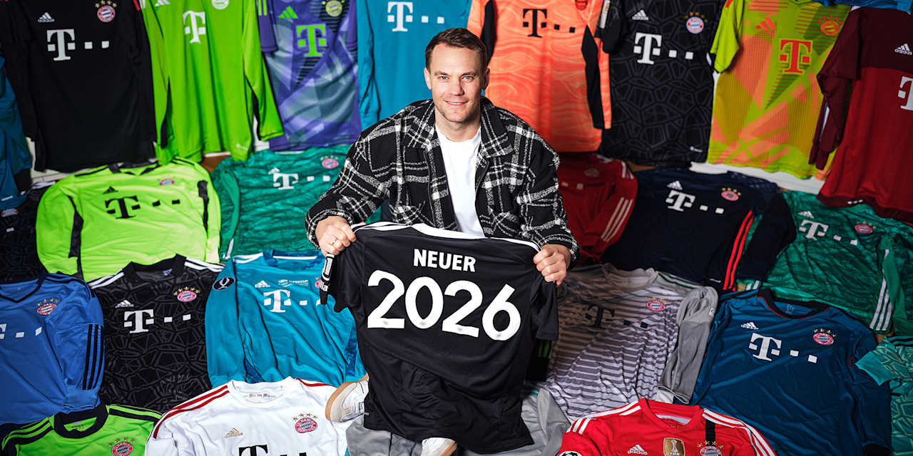 Manuel Neuer sitzt zwischen seinen Trikots des FC Bayern und hält ein Trikot mit der Neuer 2026 in der Hand