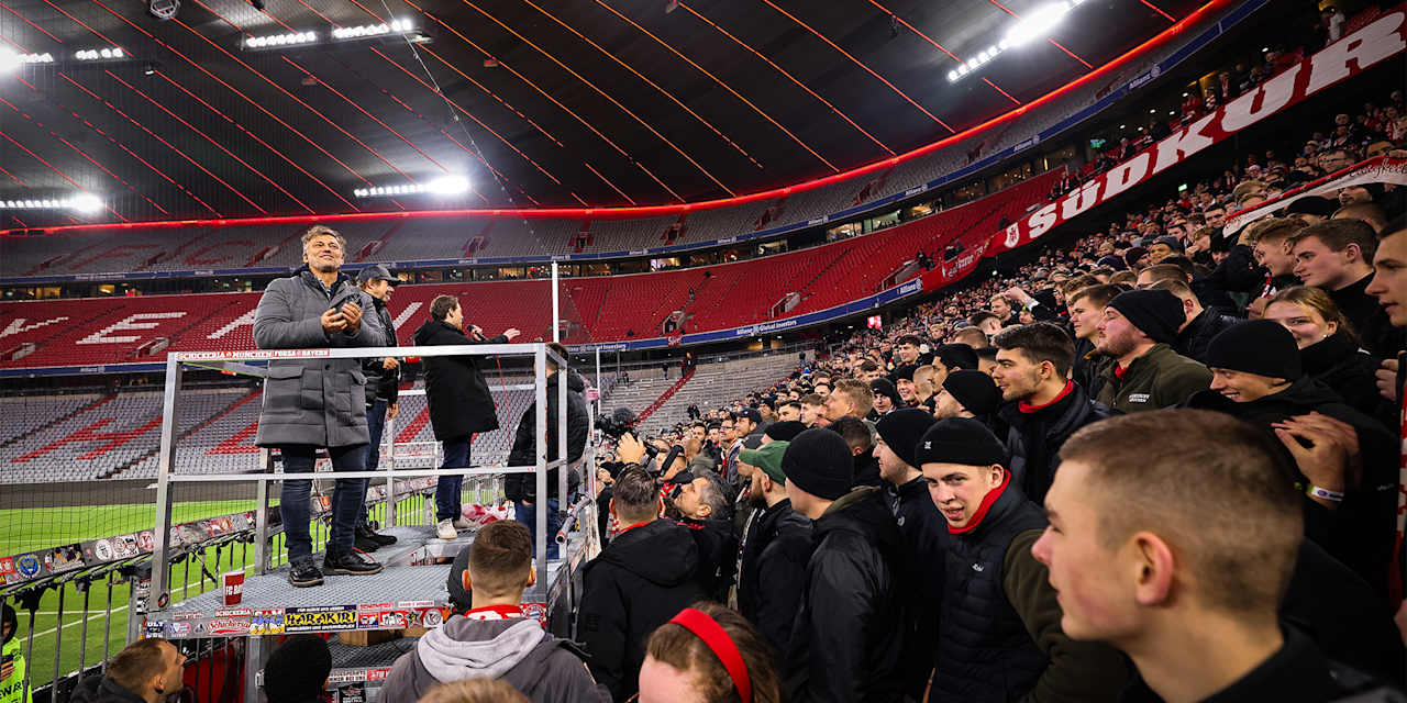 El famoso tenor Jonas Kaufmann mira desde un podio a los aficionados en la Südkurve del Allianz Arena de Múnich.