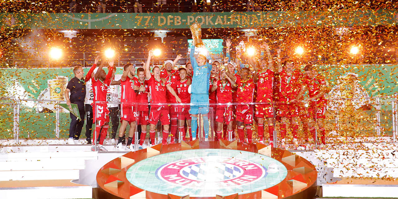 Spieler des FC Bayern jubeln mit dem DFB-Pokal im Berliner Olympiastadion.