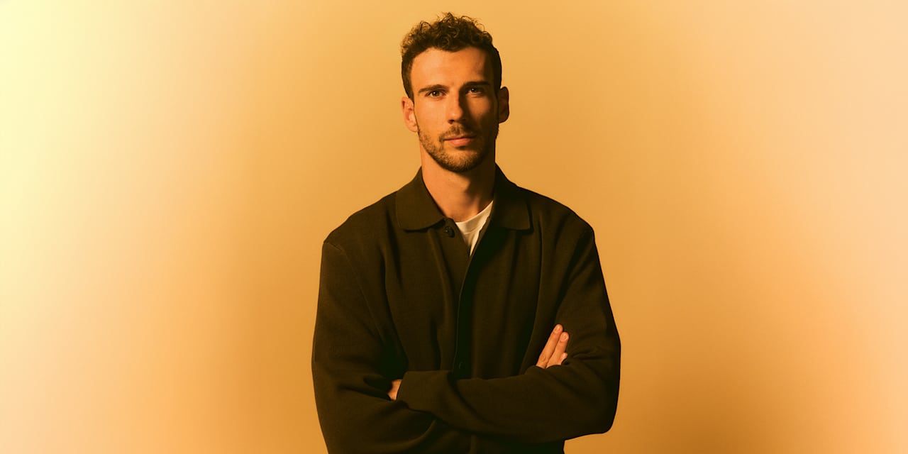 Leon Goretzka with his arms crossed in front of a yellow screen