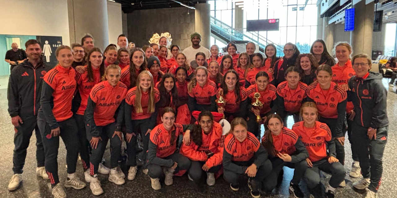 Die U17 und U15 der FC Bayern Frauen im Gruppenfoto mit zwei Pokalen und Vincent Kompany im Hintergrund