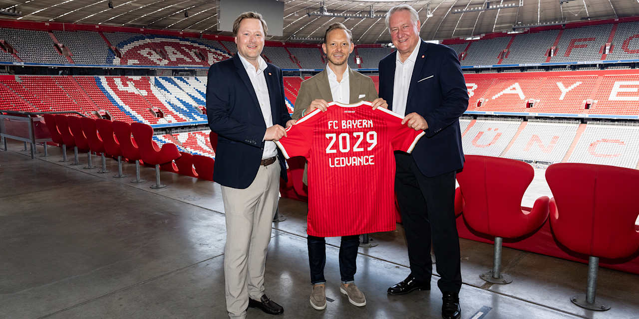 LEDVANCE-Vorstände und Rouven Kasper halten ein FC Bayern-Trikot mit der Aufschrift FC Bayern LEDVANCE 2029 hoch