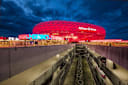 Rot erleuchtete Allianz Arena und Parkhäuser