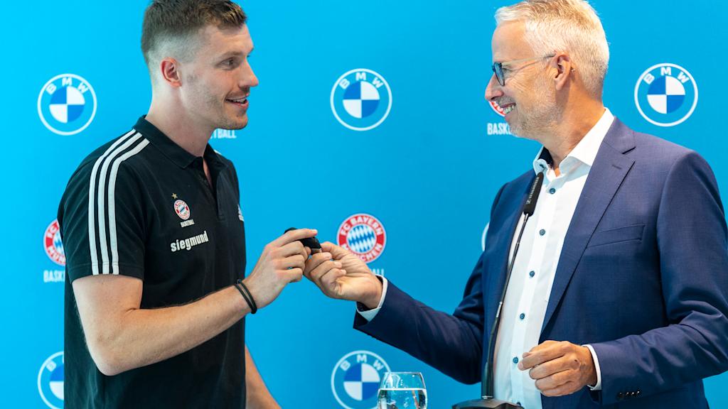 Andreas Obst receives his new car key from Bernd Döpke, Head of BMW Munich