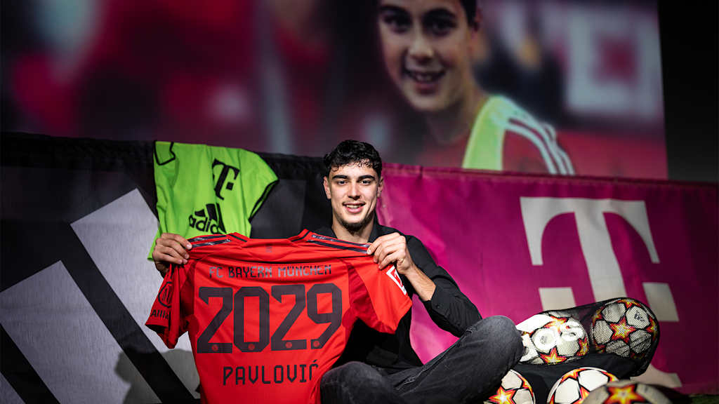 Pavlovic with an FC Bayern shirt marked 2029 in front of a picture from his youth days