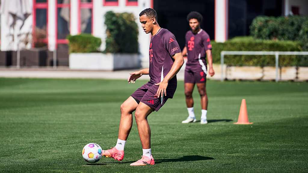 Tarek Buchmann spielt einen Pass im FC Bayern-Training. Im Hintergrund ist Serge Gnabry zu sehen.