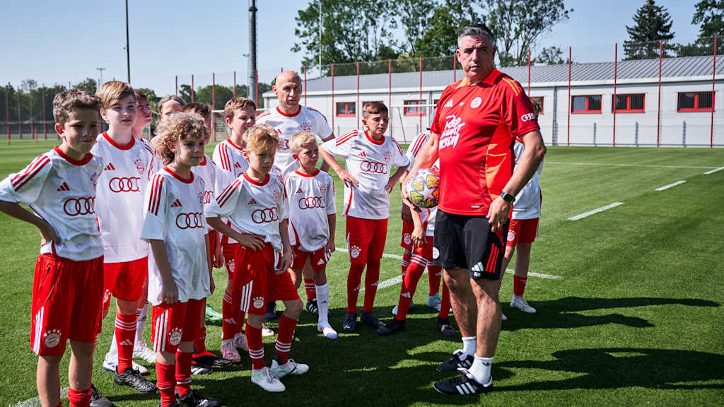 FC Bayern World Squad-Chefcoach Roy Makaay mit fußballbegeisterten Kindern