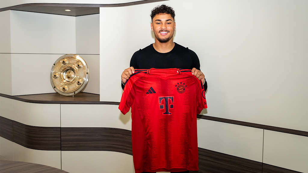 Armindo Sieb holding a Bayern jersey after signing his contract