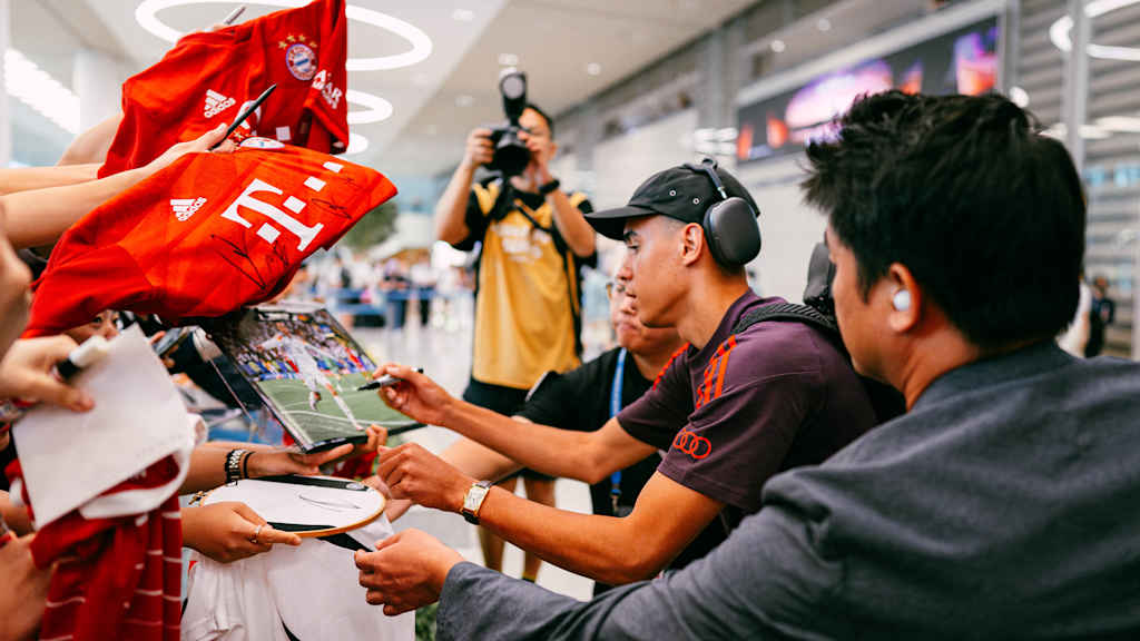 Jamal Musiala schreibt Autogramme am Flughafen Seoul.