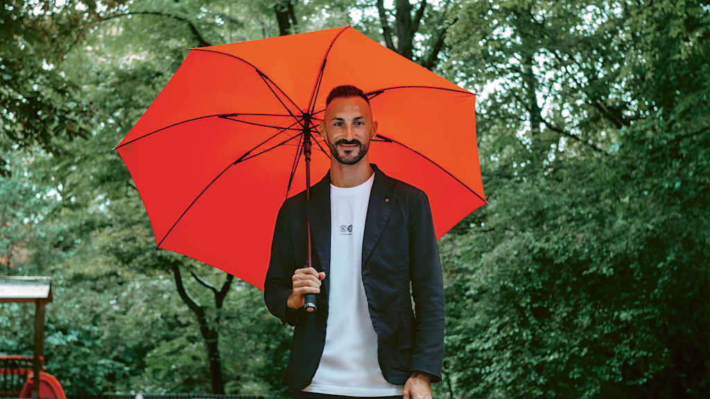 Diego Contento mit Regenschirm im Biergarten