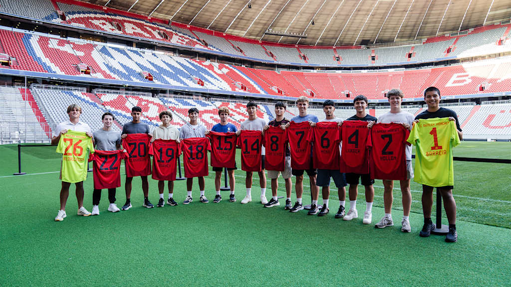 The new cohort of the FC Bayern Global Academy with their shirts in the Allianz Arena.