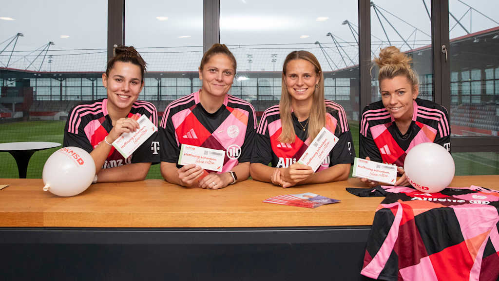 Lena Oberdorf, Anna Wellmann, Klara Bühl and Linda Dallmann from FC Bayern Women stand together at the German Bone Marrow Donor Centre's stem cell donation registration desk