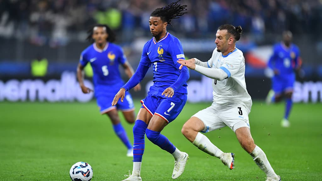 Michael Olise tussles with his opponent in the game between France and Israel