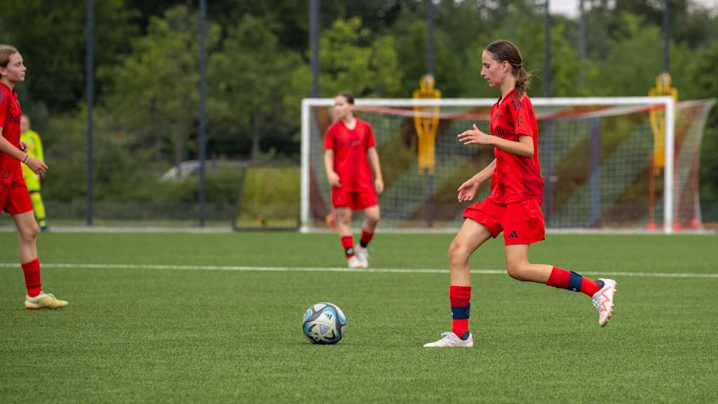 Spielerin der U15-Juniorinnen im Heimtrikot mit dem Ball am Fuß.