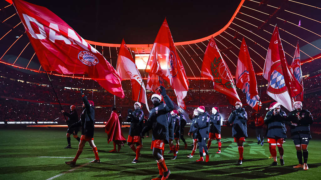 Los jugadores del FC Bayern recorren el césped del Allianz Arena con banderas tras el último partido en casa en 2023.