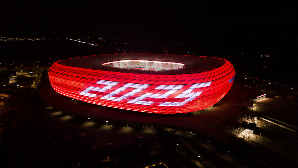 The Munich Allianz Arena lights up in red at New Year with the lettering 2025 on the façade.