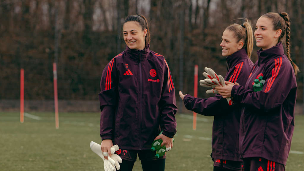 Goalkeeper Mala Grohs on the training pitch smiling with goalkeeping colleagues Anna Wellmann and Ena Mahmutovic.
