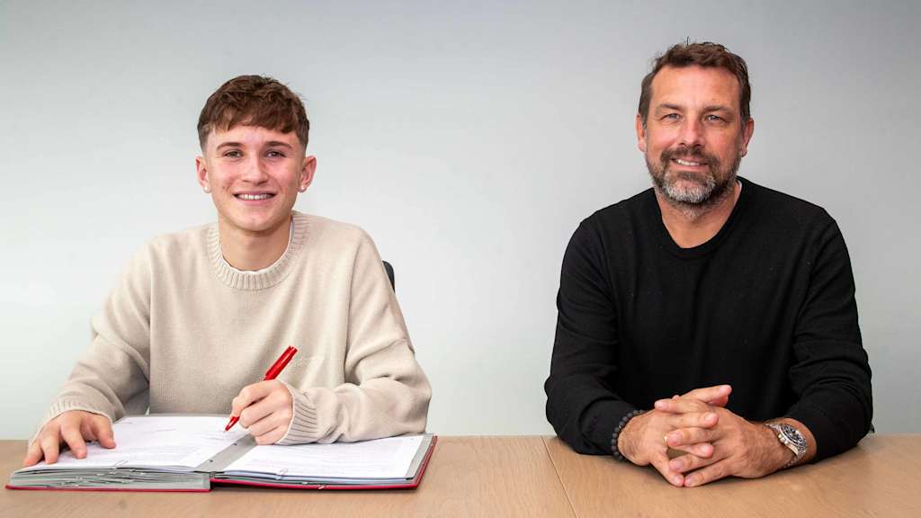 Tim Binder unterschreibt einen neuen Vertrag neben Markus Weinzierl, Sportlicher Leiter am FC Bayern Campus.