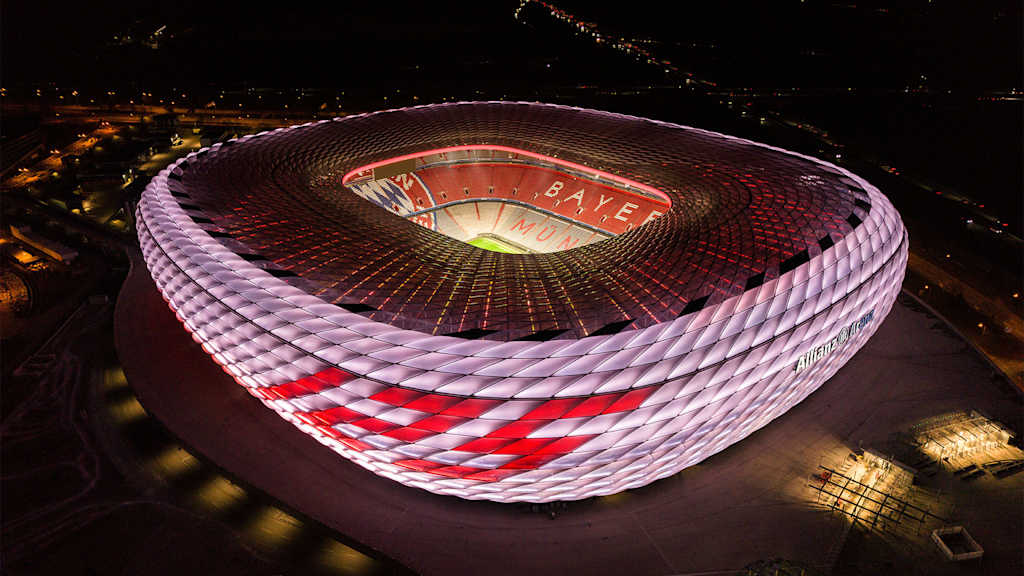 Allianz Arena leuchtet bei Nacht in Weiß mit roter 125 darauf