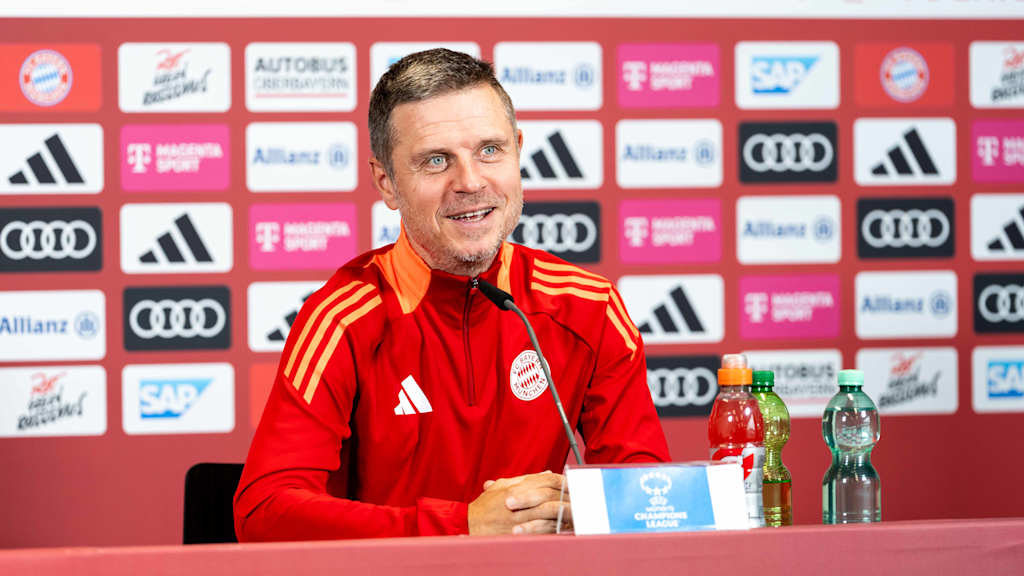 Alexander Straus sitzt im Pressekonferenz-Raum des FC Bayern.