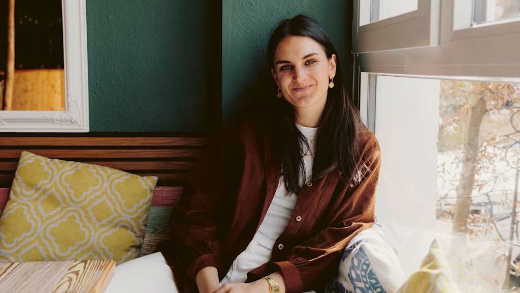 Jovana Damnjanović sits smiling in a corner of her new café.