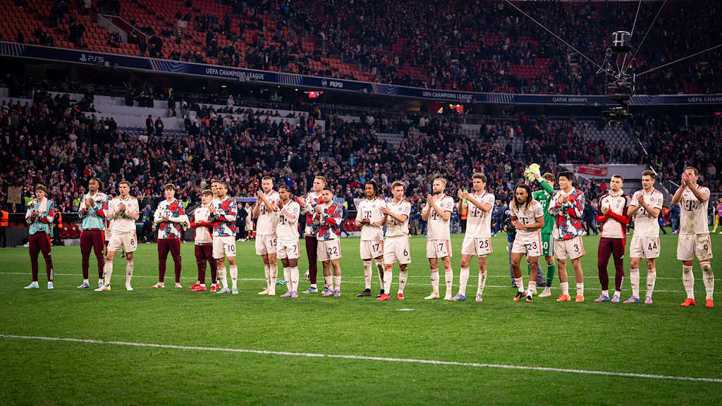 Spieler des FC Bayern klatschen vor der Südkurve