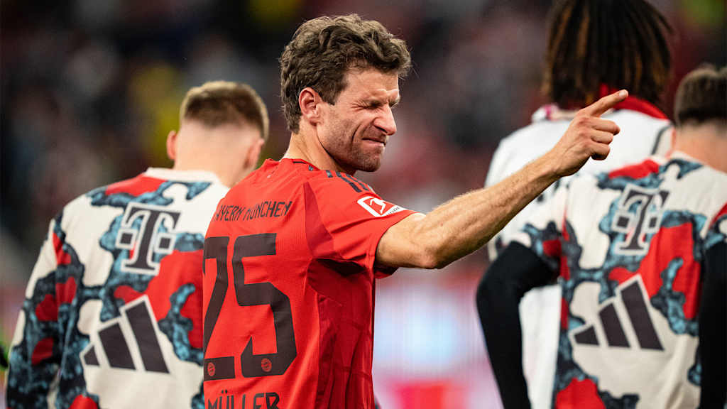 Thomas Müller kneift ein Auge zu und zeigt mit dem Finger