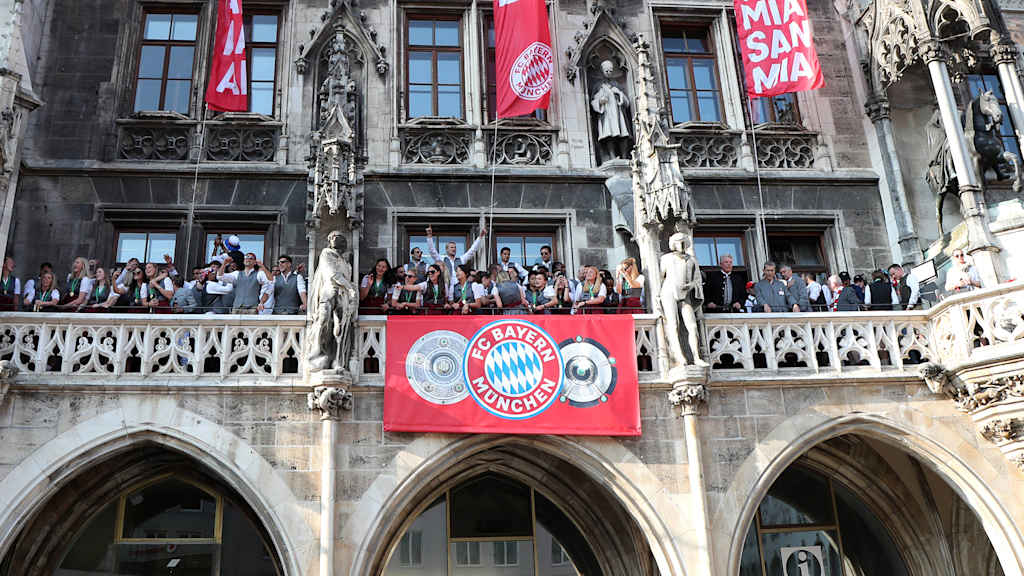 Women's and men's teams with the trophies on the Town Hall balcony in 2023