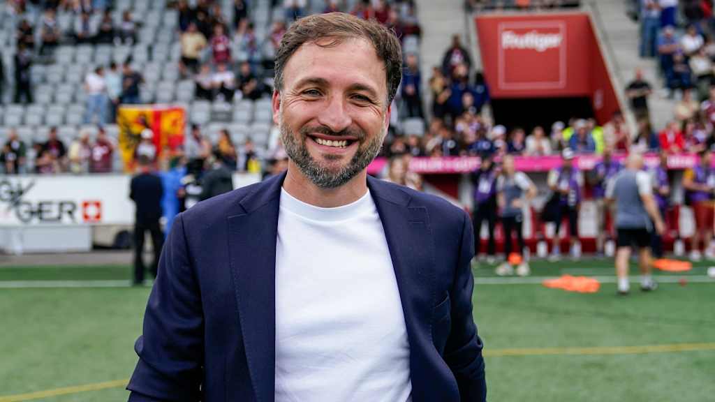 Trainer José Barcala steht im Anzug im Stadion.