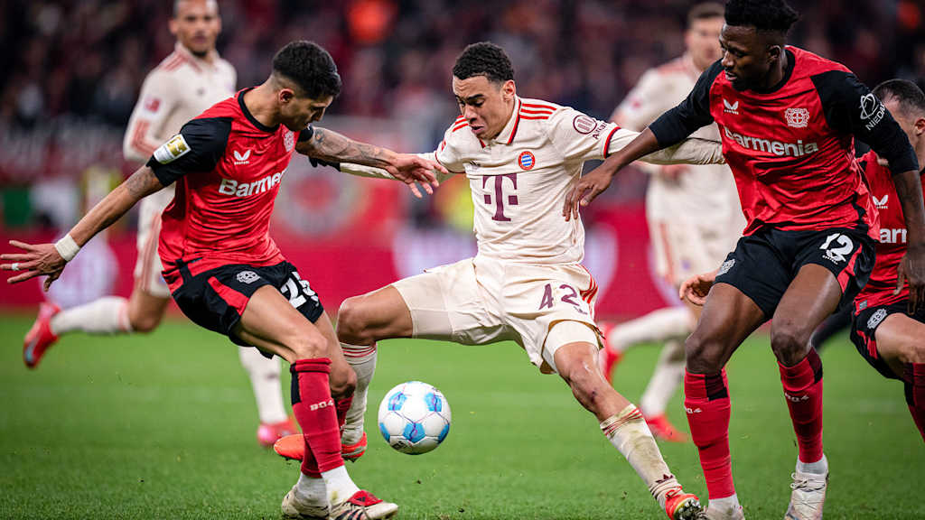 Jamal Musiala im Zweikampf mit zwei Leverkusenern.