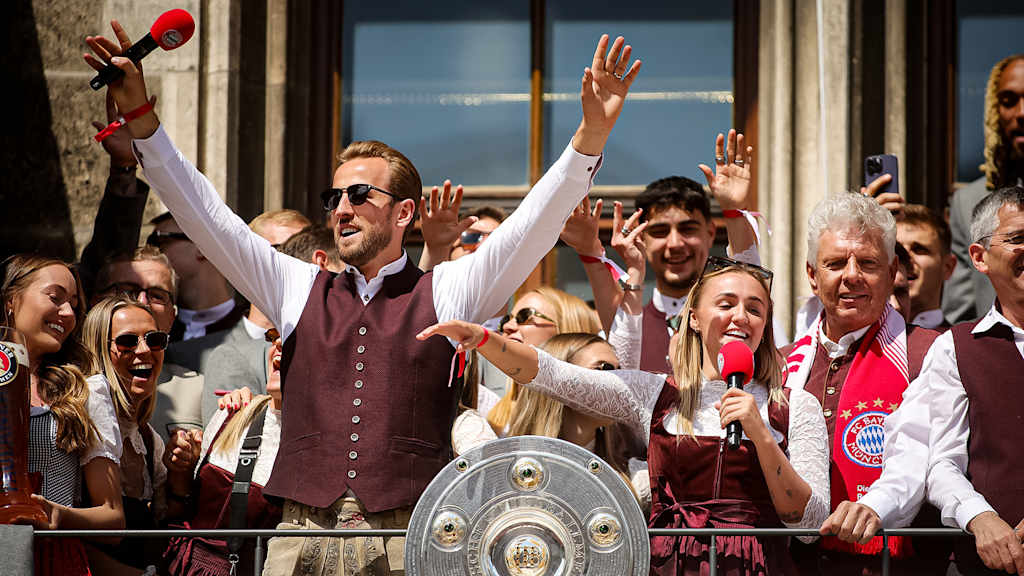 Georgia Stanway und Harry Kane singen zusammen auf dem Rathausbalkon am Münchner Marienplatz