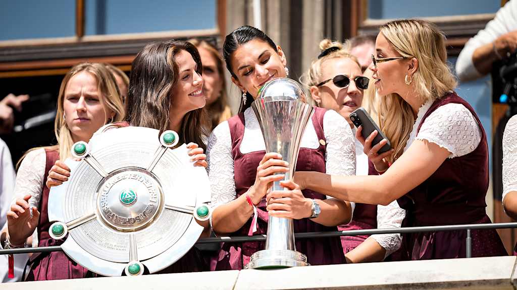 Tuva Hansen, Jovana Damnjanović und Giulia Gwinn mit der Meisterschale und dem Pokal auf dem Rathausbalkon am Marienplatz