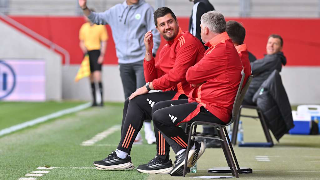 Peter Gaydarov, Trainer der FC Bayern U19, sitzt neben dem Spielfeld auf einem Stuhl.