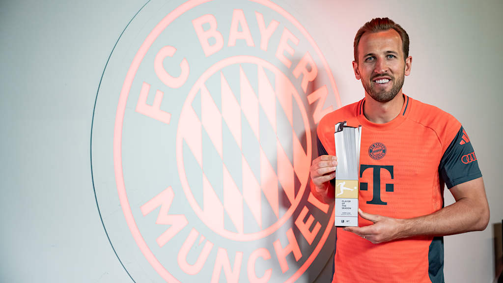 Harry Kane hält die Auszeichnung für den Bundesliga-Spieler der Saison der DFL hoch.