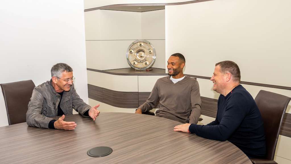 Jonathan Tah sits at a table with Herbert Hainer and Max Eberl