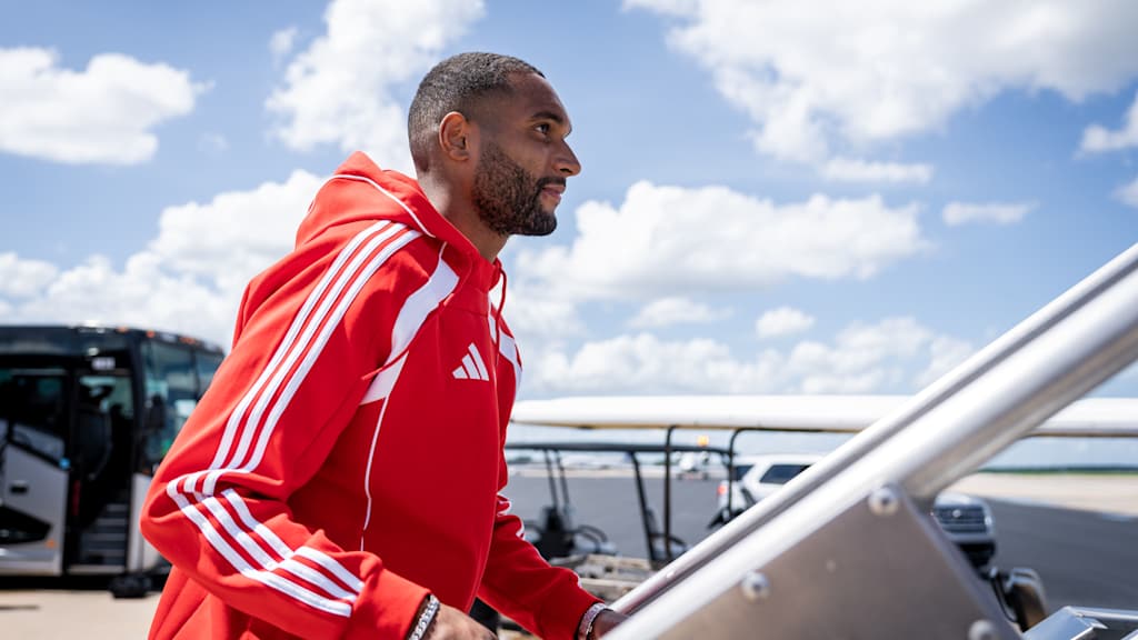 Jonathan Tah sube a un avión con la equipación roja del FC Bayern