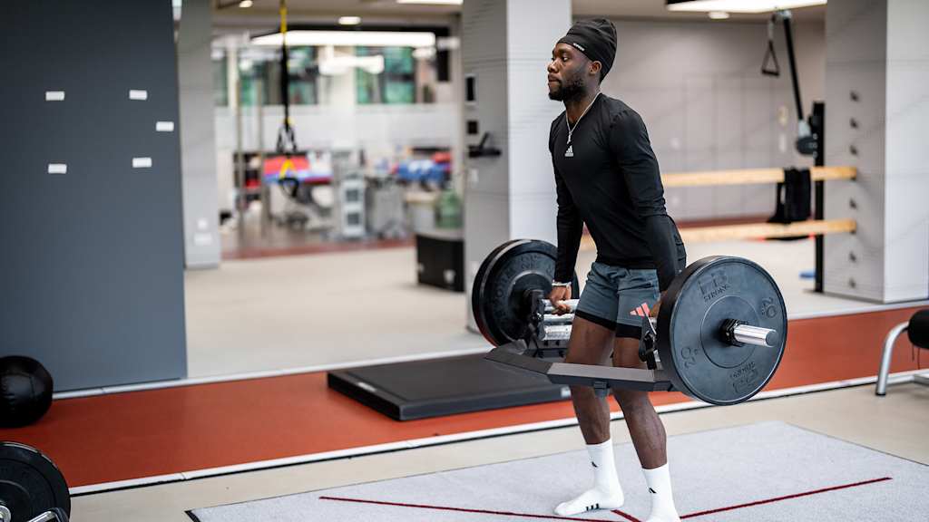 Alphonso Davies lifts a dumbbell in FC Bayern rehab training